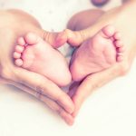 Babyvoetjes in hartvorm handen